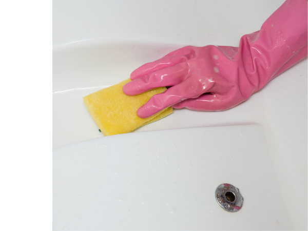Wiping Down Hot Tub Hand in pink glove wiping down hot tub surface with a yellow rag