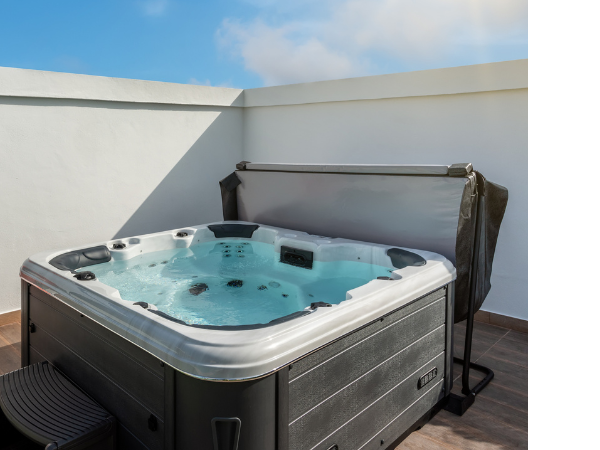 Hot Tub and Cover Outdoor hot tub with hot tub cover detached and set up behind it