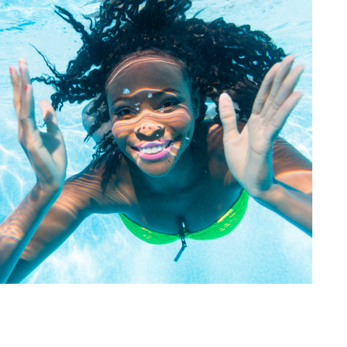 Woman Smiling for the Camera Woman posing in the pool for an underwater photo.