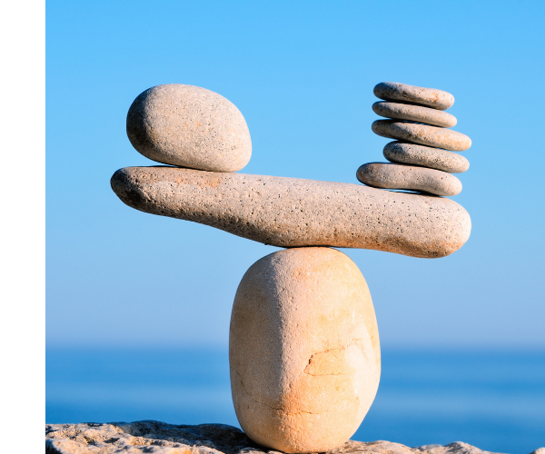 One large stone balances on a rock scale against 5 stacked stones.