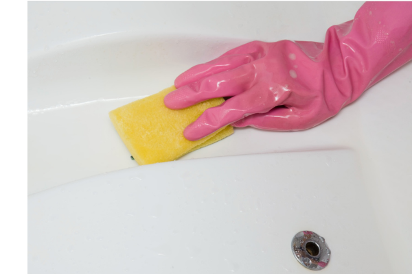 Cleaning the Hot Tub A gloved hand with a sponge wiping the surfaces of a hot tub.