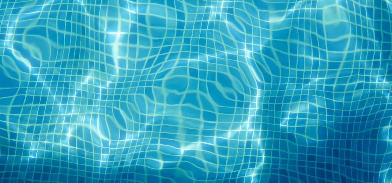 Overhead shot of pool water with a blue tiled floor