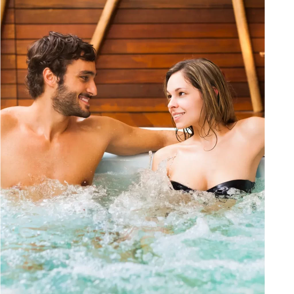 Two adults in the hot tub. They are staring at each other enjoying the hot bubbling water.
