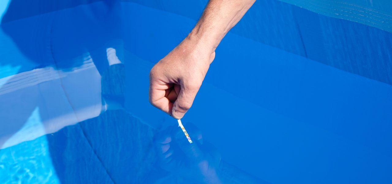 A hand dips a test srp into a pool