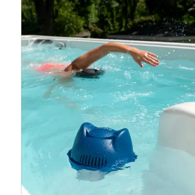 FROG @ease for Swim Spas floats in a swim spa as a man swims in the background