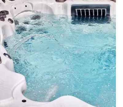 An overhead shot of a hot tub with its jets on. Its water is cloudy.
