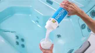 FROG® Soothe® — Raising Total Hardness for Hot Tub Water FROG® Soothe® being poured into a TruDose™ cap above a hot tub — raises total hardness for balanced, comfortable water.